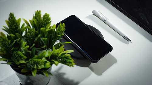 cell phone smartphone place on wireless charger on table electronics